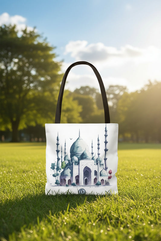 A white canvas tote bag with black shoulder straps, featuring a watercolor-style illustration of a mosque with blue-green domes and minarets on the front.